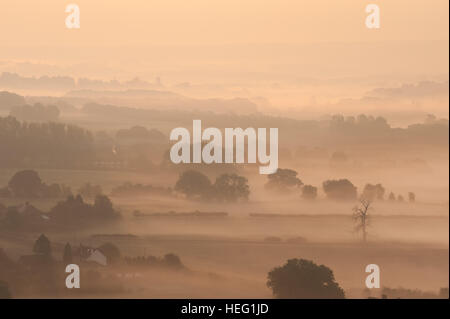Dawn sunrise over Northdowns valley looking towards Mereworth Woods Charing Hills mist being burnt off by rising sun autumn Stock Photo