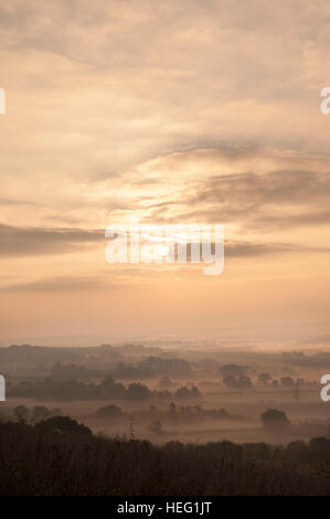 Dawn sunrise over Northdowns valley looking towards Mereworth Woods Charing Hills mist being burnt off by rising sun autumn Stock Photo