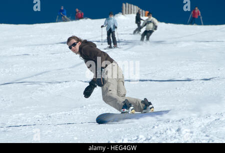 Snowboarder and skiers skiing and snowboarding down a slope, run, Stuhleck Ski Area, Semmering, Styria, Austria Stock Photo