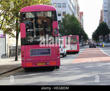 Buses in Belfast city centre, beside bus lane and enforcement signs. Stock Photo