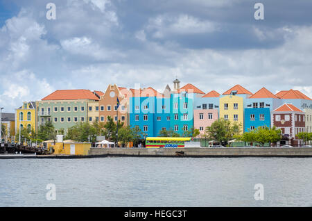 Curacao, Caribbean - October 2, 2012: Willemstad daylight in Curacao. Handelskade with colorful facades and Queen Emma Bridge Stock Photo