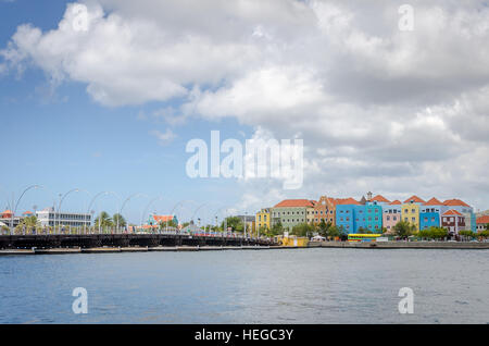 Curacao, Caribbean - October 2, 2012: Willemstad daylight in Curacao. Handelskade with colorful facades and Queen Emma Bridge Stock Photo