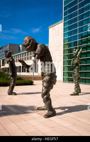 Germany, Essen, bronze sculptures  in front of the glas foyer of the Philharmonie, Saalbau. Stock Photo