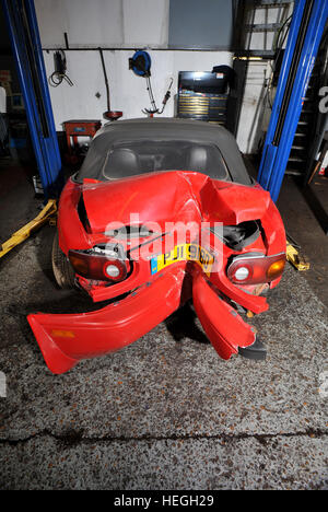 Car wreck. Crash damaged Mk1 Mazda MX5 with the rear bumper folded double after hitting a post backwards (no one was injured) Stock Photo