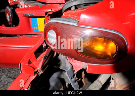 Car wreck. Crash damaged Mk1 Mazda MX5 with the rear bumper folded double after hitting a post backwards (no one was injured) Stock Photo