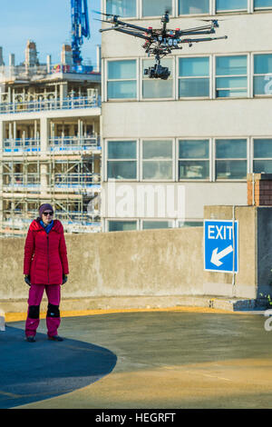 The piece was filmed by a drone - Gold Zero by American artist Corrie Baldauf (pictured in red) - she used use 200 litres of iridescent gold Liquitex paint to covering 230 square metres of concretea with a giant gold zero on the roof of the ex-BBC Television Centre.   The project, supported by Griffin Gallery and White Noise, signifies the end of the Corrie’s three-month artist residency at Griffin Gallery. Stock Photo