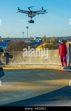 The piece was filmed by a drone - Gold Zero by American artist Corrie Baldauf (pictured in red) - she used use 200 litres of iridescent gold Liquitex paint to covering 230 square metres of concretea with a giant gold zero on the roof of the ex-BBC Television Centre.   The project, supported by Griffin Gallery and White Noise, signifies the end of the Corrie’s three-month artist residency at Griffin Gallery. Stock Photo