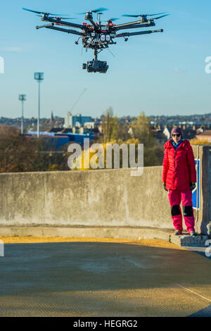 The piece was filmed by a drone - Gold Zero by American artist Corrie Baldauf (pictured in red) - she used use 200 litres of iridescent gold Liquitex paint to covering 230 square metres of concretea with a giant gold zero on the roof of the ex-BBC Television Centre.   The project, supported by Griffin Gallery and White Noise, signifies the end of the Corrie’s three-month artist residency at Griffin Gallery. Stock Photo