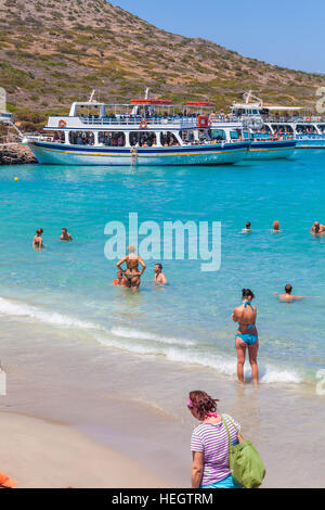 AGIOS NIKOLAOS, GREECE - JULY 31, 2012:  Tourists swim in the Mediterranean sea on the beach after the excursion to the island of Spinalonga Stock Photo