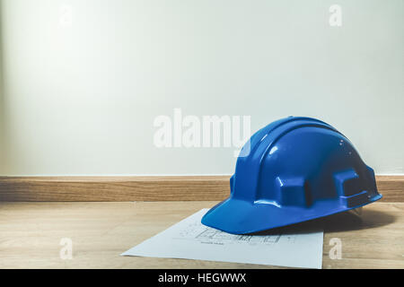 Safety blue helmet and home construction plan, architecture or construction or industrial equipments, with copy space, engineering concept, soft light Stock Photo