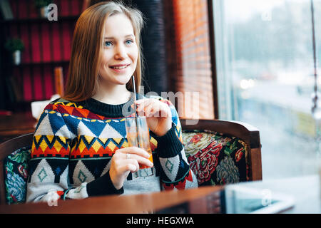 Photo of a woman drinking juice through  window Stock Photo