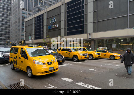 NEW YORK - MAY 3, 2016: Typically yellow medallion taxicabs in front of the New York Hilton. They are widely recognized icons of the city and come in Stock Photo