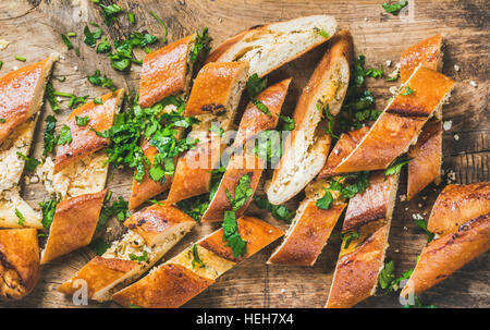Close-up of Turkish oriental pizza pide with cheese and spinach chopped in slices on rustic wooden background, top view Stock Photo