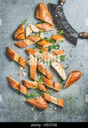 Turkish oriental pizza pide with cheese and spinach chopped in slices on grey stone background, top view, vertical composition Stock Photo
