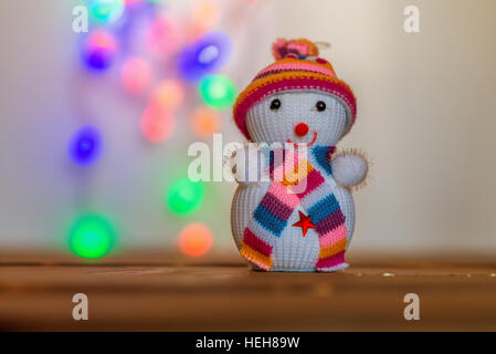 Snowman figurine.Blurry Christmas lights out of focus in the background. Bokeh