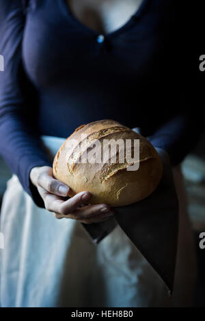 Woman holding a loaf of bread Stock Photo