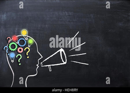 Coaching concept – knowledge and ideas sharing with human head shape and megaphone or bullhorn on blackboard Stock Photo