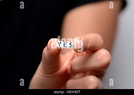 YES word from white plastic letter blocks in woman hand Stock Photo