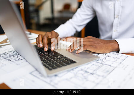 Human hands typing on laptop over sketch Stock Photo