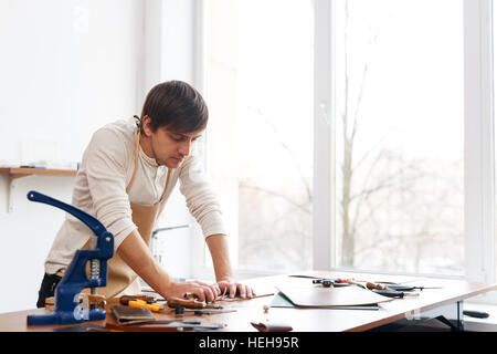 Tanner standing by workplace and working Stock Photo