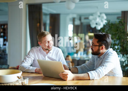 Two economists discussing sales data online Stock Photo