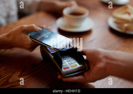 Customer making contactless payment through smartphone Stock Photo