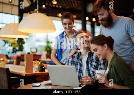Group of young colleagues or students discussing plans or ideas in cafe Stock Photo