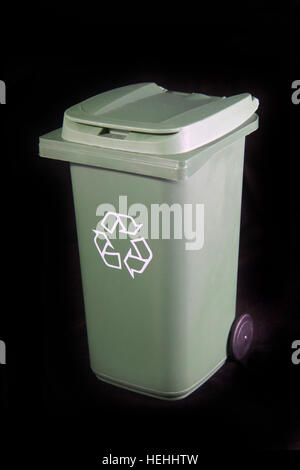 Green recycle rubbish or garbage bin with the recycle symbol on a black background. Stock Photo