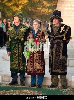 Russian cosmonaut Gennady Padalka (left) of Roscosmos, American astronaut Peggy Whitson of NASA, and Russian cosmonaut Valery Korzun of Roscosmos wear traditional Kazakh dress during a ceremony recognizing their achievements in space fight September 23, 2010 in Jhezkazgan, Kazakhstan. Stock Photo