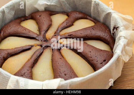 freshly made pear and chocolate cake in a round mold Stock Photo