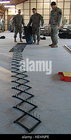 Members of the 56th Stryker Brigade Combat Team, 28th Infantry Division, practice laying out spike strips during non-lethal capability set training at Fort Dix, N.J. Flickr - The U.S. Army - Spike strip Stock Photo