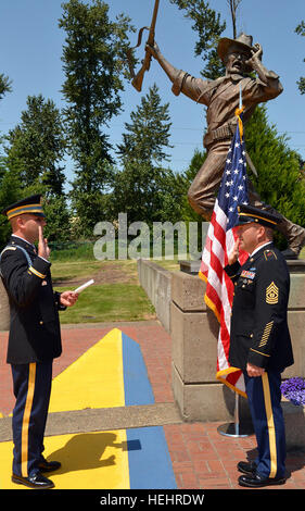 Capt. Nick Conley (left), commander of the Oregon National Guard's Delta Company, 2nd Battalion, 162nd Infantry Regiment, administers the enlistment oath to his father, Command Sgt. Maj. Brunk Conley (right), senior enlisted adviser to the adjutant general, Oregon, during an extension ceremony at the Oregon Military Department's Heritage Park, July 6, in Salem, Ore. Son extends Oregon National Guard state command sergeant major 619735 Stock Photo
