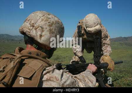 Sgt. Andrew T. Pizzutelli, 28, Greenville, N.C., Combat Skills Training School Instructor, Military Police Company, Combat Logistics Regiment 17, 1st Marine Logistics Group, shows a Marine how to properly change the barrel of a M2 .50 caliber machine gun during the CST .50 cal. course here March 13. The course is designed to teach Marines the basic functions and capabilities of the weapons systems being used in combat. Combat skills instructors use experience to better Marines in combat situations 158460 Stock Photo