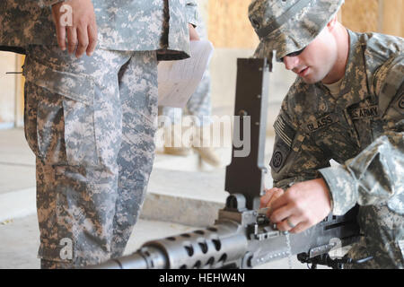 Staff Sgt. Tim Glass, of Bedford, Iowa, assigned to the 1st Battalion, 505th Parachute Infantry Regiment, 3rd Brigade Combat Team, 82nd Airborne Division, Multi-National Division-Baghdad, performs a functions check on a .50 cal machine gun during the hands-on evaluation of the Sgt. Audie Murphy board April 11 Joint Security Station Loyalty, located in eastern Baghdad. The board was a two-day event which test NCOs on a variety of military knowledge and warrior skills. Twelve NCOs were nominated for membership will move on to the division level and be evaluated by the division club members. Para Stock Photo