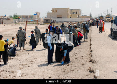 Dujaylah police, 3rd Battalion, 32nd Iraqi Army Brigade, and 2nd Battalion, 20 Field Artillery Regiment Soldiers, pick up trash during Dujaylah Pride Day. The event showed the local community the unity between Iraqi security forces, Government of Iraq and coalition forces to strengthen community ties. Iraqi security forces lead the way for Dujaylah Pride Day 166215 Stock Photo