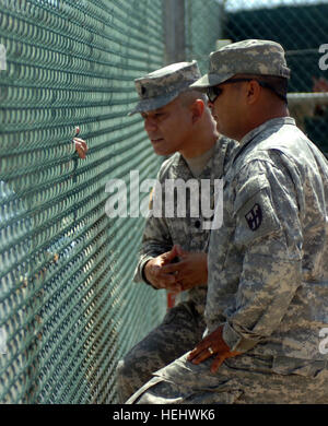 GUANTANAMO BAY, Cuba – Army Lt. Col. Miguel Mendez, detainee programs director at Joint Task Force Guantanamo, listens to a detainee who requested particular books from the library at Camp 4, April 23, 2009. JTF Guantanamo conducts safe, humane, legal and transparent care and custody of detainees, including those convicted by military commission and those ordered released. The JTF conducts intelligence collection, analysis and dissemination for the protection of detainees and personnel working in JTF Guantanamo facilities and in support of the Global War on Terror. JTF Guantanamo provides supp Stock Photo