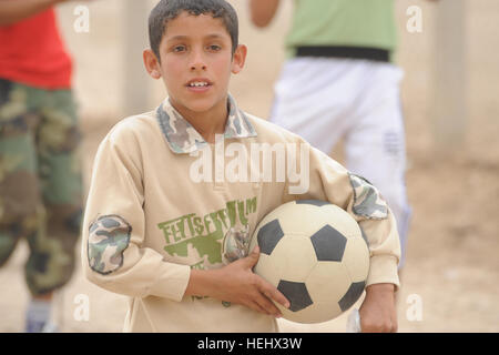 An Iraqi boy holds a soccer ball in Karadah, eastern Baghdad, Iraq on May 8. The local Iraqi public was invited to watch Joint teams of U.S. Soldiers of 3rd Brigade Combat Team, 82nd Airborne Division and Iraqi national police play against each other at a local soccer field. Soccer game in Baghdad, Iraq 172409 Stock Photo