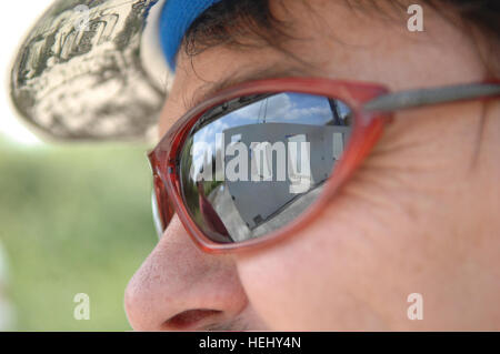 A reflection, of the construction, of the new multi-stories Military Operations in Urban Terrain (MOUT) building is shown on protective glasses, worn by Mr Blaine Curtis, Chief, Training Support Center (TSC) Benelux, at Alliance Home Station Training Area, in Chi?vres, Belgium, June 3, 2009.  Mr Curtis visits the MOUT site managed by the TSC and funded by U.S. Army Garrison Benelux. (U.S. Army photo by Pierre-Etienne Courtejoie/Released) US Army 52871 Title Stock Photo