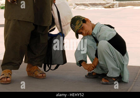 Jaweed Noor, a 10-year-old Afghan boy, escorted by his father, Ahmad, and U.S. Special Forces soldiers, prepares to board an aircraft and fly home. Jaweed was diagnosed with terminal cancer and received treatment at a military hospital on Bagram Air Base, Afghanistan. U.S. Special Forces Aid Afghan Boy 95144 Stock Photo