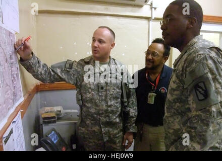 US Army 52034 During a July 24 planning meeting, Lt. Col. William B. Smith, Jr. (left), COL Q-West Mayor, outlines a mission to catalog valve boxes and major taps on the Q-West water pipeline to Reinaldo Guebara (m Stock Photo