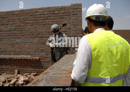 Engineers from the Nangarhar Provincial Reconstruction Team supervise the construction of a boys school in Nangarhar province, Afghanistan, inspecting progress and reviewing building methods at Forward Operating Base Finley Shields. Stock Photo