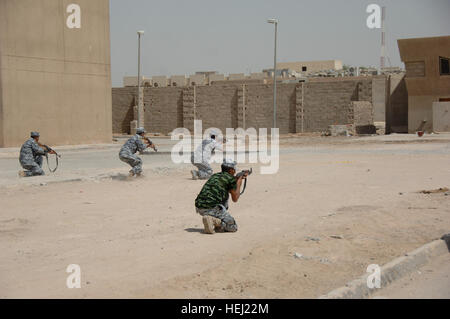 Iraqi security forces from the 1st National Police Division, practice battle movement scenarios taught by U.S. Soldiers assigned to the 3rd Brigade Combat Team, 82nd Airborne Division, at Forward Operating  Base Loyalty, near Baghdad, Iraq, Aug. 19. Iraqi security force members learn battle movement skills 197163 Stock Photo