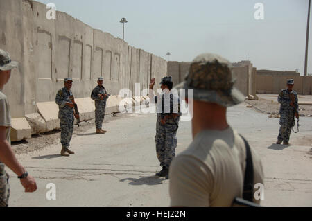 Iraqi security forces from the 1st National Police Division, practice battle movement scenarios taught by U.S. Soldiers assigned to the 3rd Brigade Combat Team, 82nd Airborne Division, at Forward Operating  Base Loyalty, near Baghdad, Iraq, Aug. 19. Iraqi security force members learn battle movement skills 197170 Stock Photo