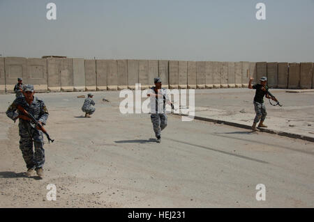 Iraqi security forces from the 1st National Police Division, practice battle movement scenarios taught by U.S. Soldiers assigned to the 3rd Brigade Combat Team, 82nd Airborne Division, at Forward Operating  Base Loyalty, near Baghdad, Iraq, Aug. 19. Iraqi security force members learn battle movement skills 197175 Stock Photo