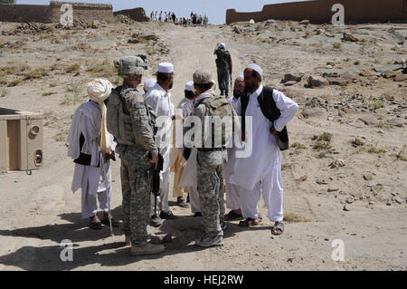 FORWARD OPERATING BASE SALERNO, Afghanistan – An Afghan National Policeman from the Sar Hawza district of Paktika province, Afghanistan walks up towards a gathering crowd of local Afghans to answer questions they have, Sept. 7, as a U.S. Army Soldier talks with village elders during a joint operations with Paratroopers from 1st Battalion, 501st Parachute Infantry Regiment, 4th Brigade Combat Team, 25th Infantry Division and Soldiers from Police Mentoring Team. The joint mission in support of Operation Thunder Darau involved the ANSF and International Security Assistance Forces within Paktika,  Stock Photo