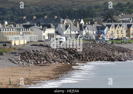 Costal road on the Wild Atlantic Way in Ireland running through the village of Waterville with its colourful seafront houses and stoney beach.. Stock Photo