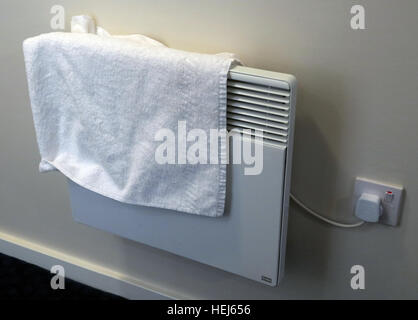 Drying towels or clothes on electric convection heaters,danger of fire Stock Photo