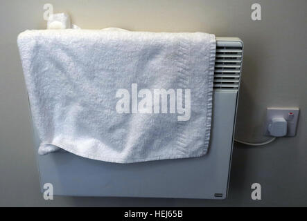 Drying towels or clothes on electric convection heaters, danger of fire Stock Photo