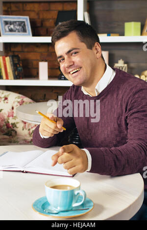 Man holding pencil and writing on a paper in the diary Stock Photo