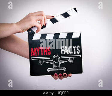 Myths vs Facts Balance. Female hands holding movie clapper. Stock Photo